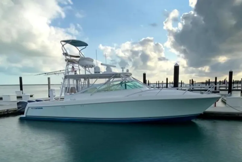 Slide: The Image of 2008 Contender 38 Express boat docked at marina under cloudy sky. - 0