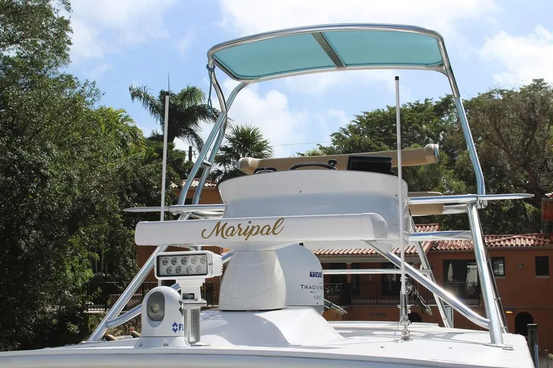 Slide: The Image of 2008 Contender 38 Express boat with tower and radar, docked near tropical foliage. - 3