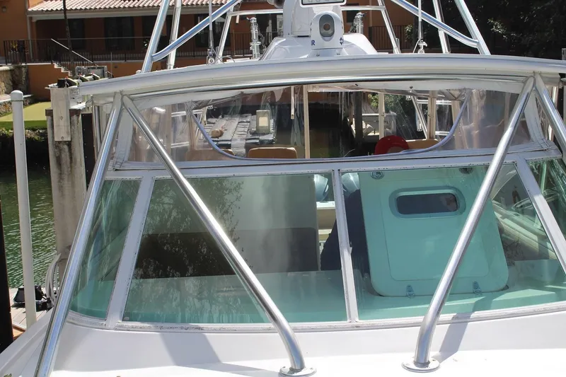 Slide: The Image of 2008 Contender 38 Express boat docked, featuring a sleek windshield and sturdy frame. - 4