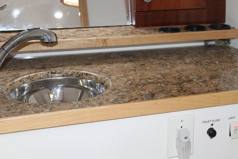 Slide: The Image of 2008 Contender 38 Express boat interior with granite countertop and stainless steel sink. - 49