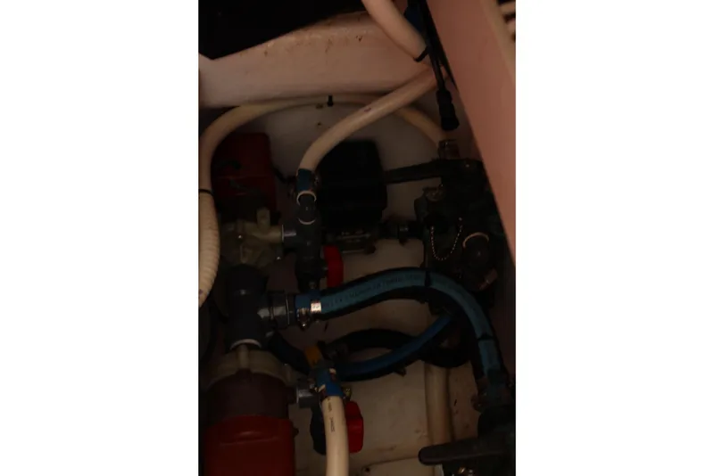 Slide: The Image of Engine compartment of a 2008 Contender 38 Express boat with visible hoses and fittings. - 54