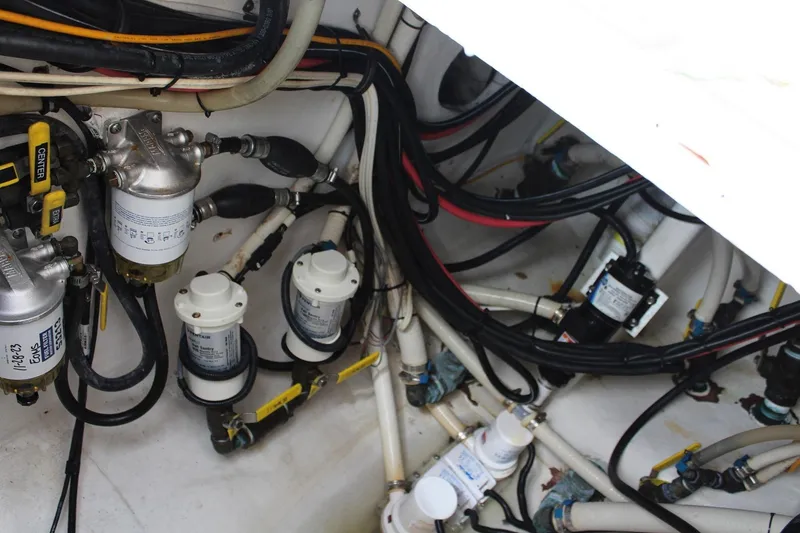 Slide: The Image of Engine compartment of a 2008 Contender 38 Express boat, showcasing wiring and fuel filters. - 60