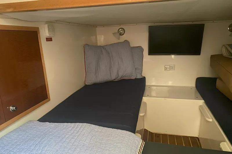 Slide: The Image of 2008 Contender 38 Express cabin interior with twin beds and wall-mounted TV. - 74