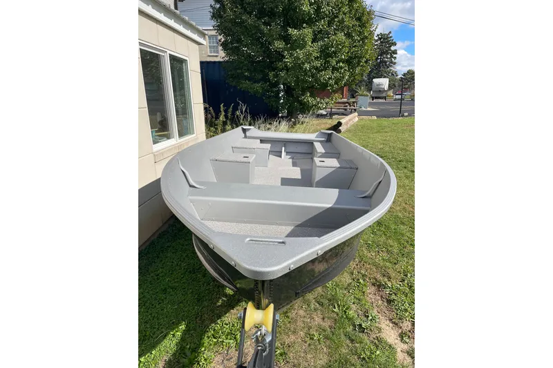 Slide: The Image of 2026 Alumacraft V14 boat on grass, near a building and tree. - 4