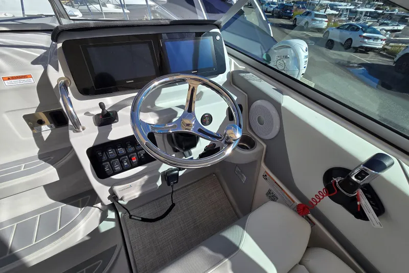 Slide: The Image of 2026 Regal 26 XO boat helm with steering wheel, controls, and navigation screens. - 6
