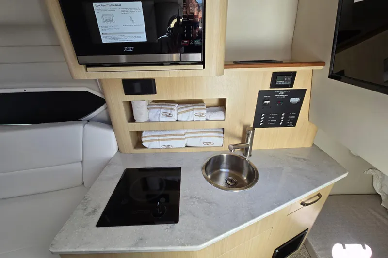 Slide: The Image of 2026 Regal 26 XO boat interior with kitchenette, sink, and control panel. - 8