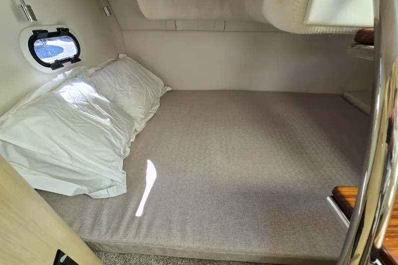 Slide: The Image of Cozy cabin bed inside 2026 Regal 26 XO boat with window and pillows. - 9