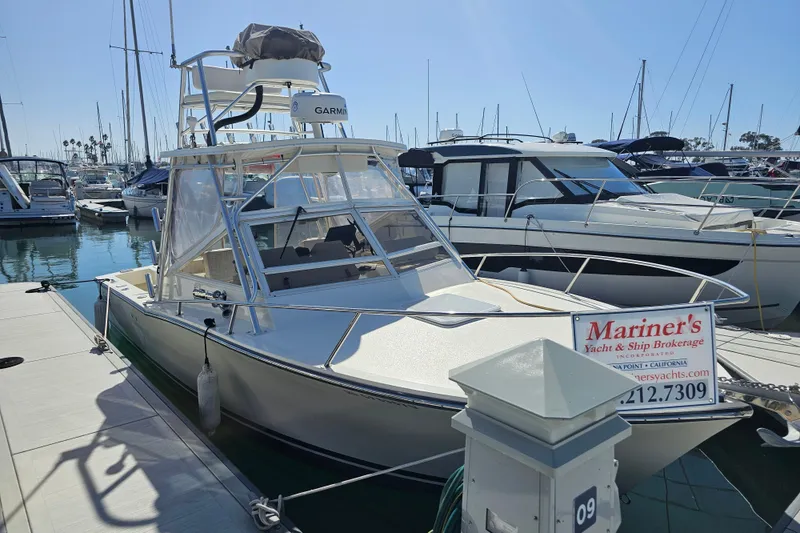 The Image of 2006 Carolina Classic 25 Express boat docked at marina with brokerage sign. - 0