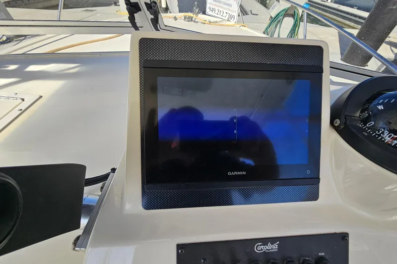 Slide: The Image of 2006 Carolina Classic 25 Express boat dashboard with Garmin navigation display. - 13