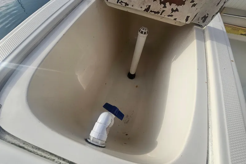 Slide: The Image of 2006 Carolina Classic 25 Express boat interior compartment with drainage pipe. - 15