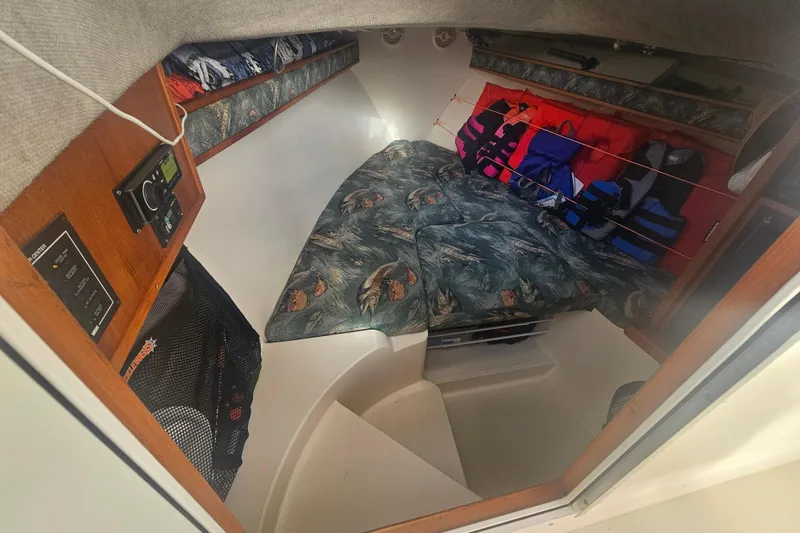 Slide: The Image of 2006 Carolina Classic 25 Express cabin interior with patterned cushions and life jackets. - 16