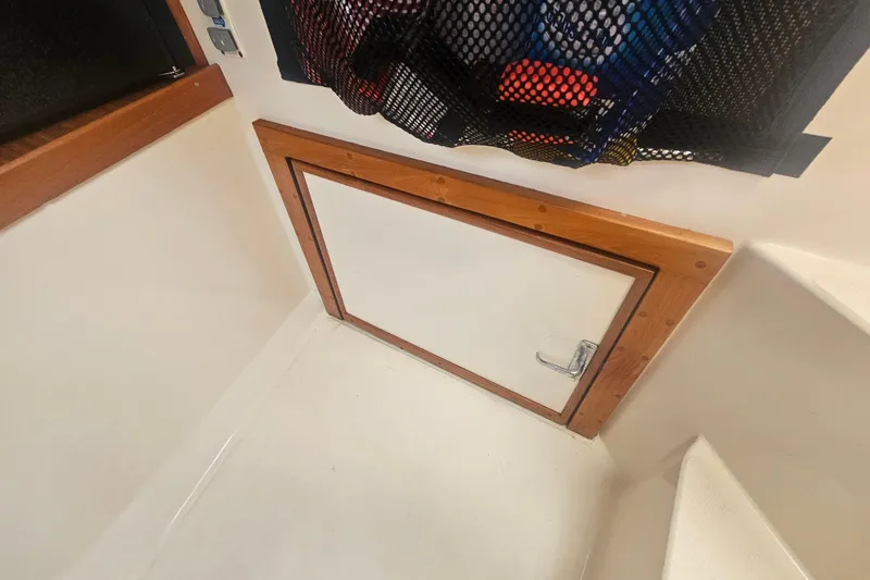 Slide: The Image of 2006 Carolina Classic 25 Express cabin interior with storage compartment and mesh netting. - 18