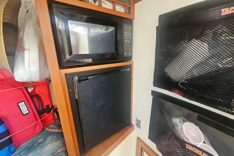 Slide: The Image of Interior of 2006 Carolina Classic 25 Express with microwave and storage compartments. - 19