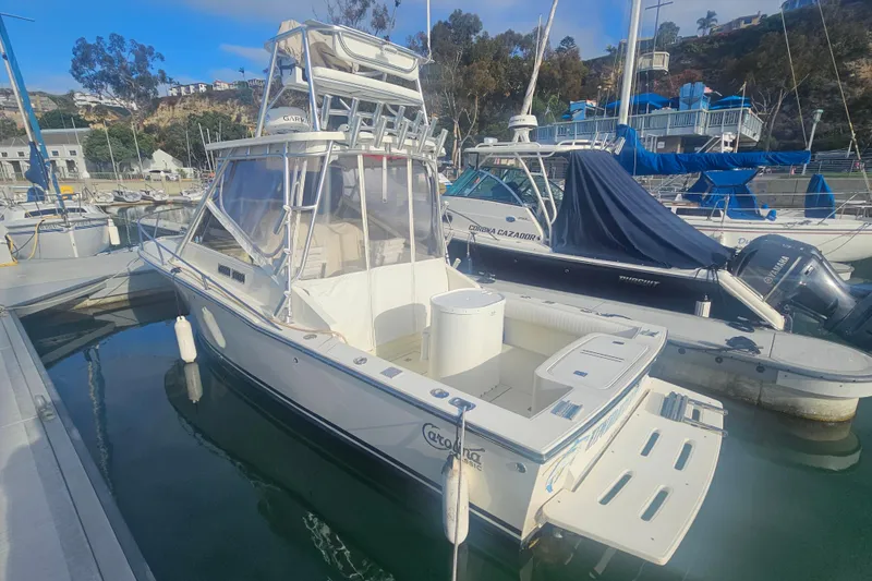 Slide: The Image of 2006 Carolina Classic 25 Express boat docked in a marina, surrounded by other vessels. - 2