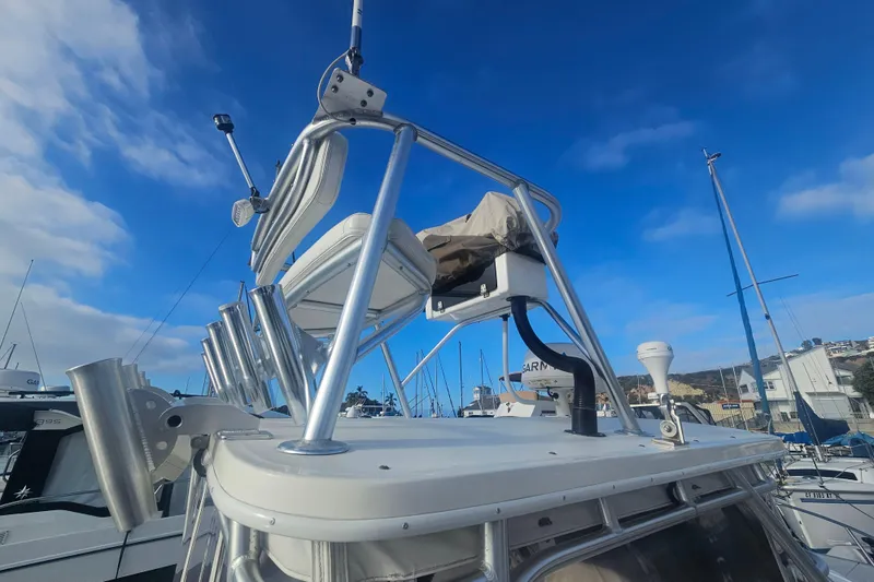 Slide: The Image of 2006 Carolina Classic 25 Express boat with tower and rod holders under a clear blue sky. - 23