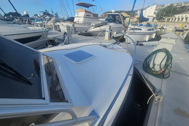 Slide: The Image of 2006 Carolina Classic 25 Express boat docked at a marina, surrounded by other vessels. - 25