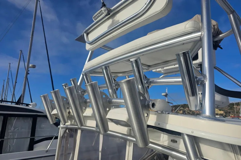 Slide: The Image of 2006 Carolina Classic 25 Express boat with rod holders and seating, under clear blue sky. - 5