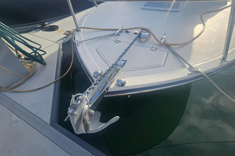 Slide: The Image of 2006 Carolina Classic 25 Express boat anchored at a dock with visible anchor chain. - 7