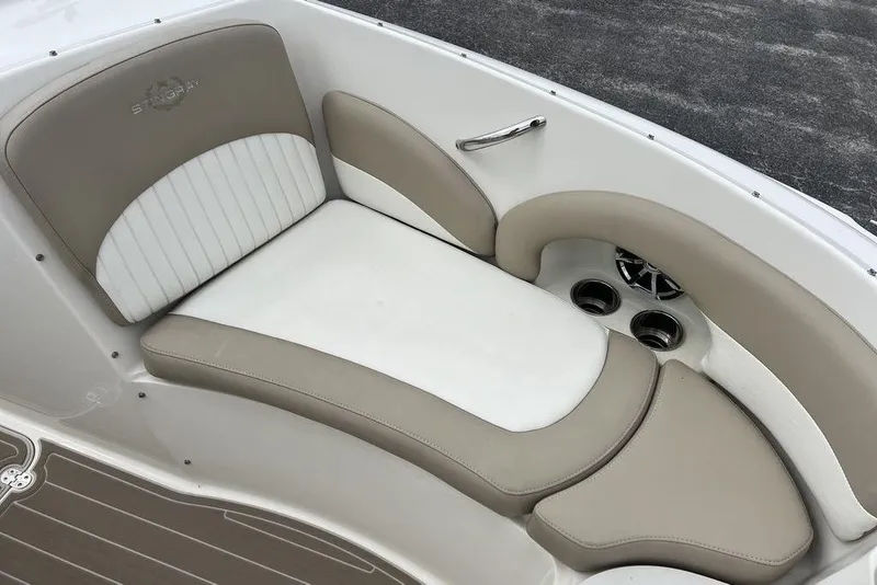 Slide: The Image of 2015 Stingray 234LR boat interior with beige and white cushioned seating. - 11