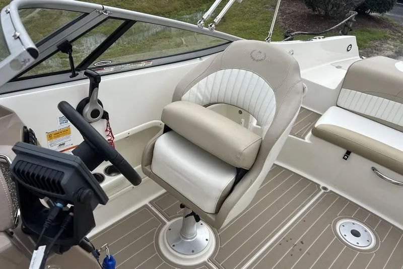 Slide: The Image of 2015 Stingray 234LR boat interior with steering wheel and beige seating. - 13