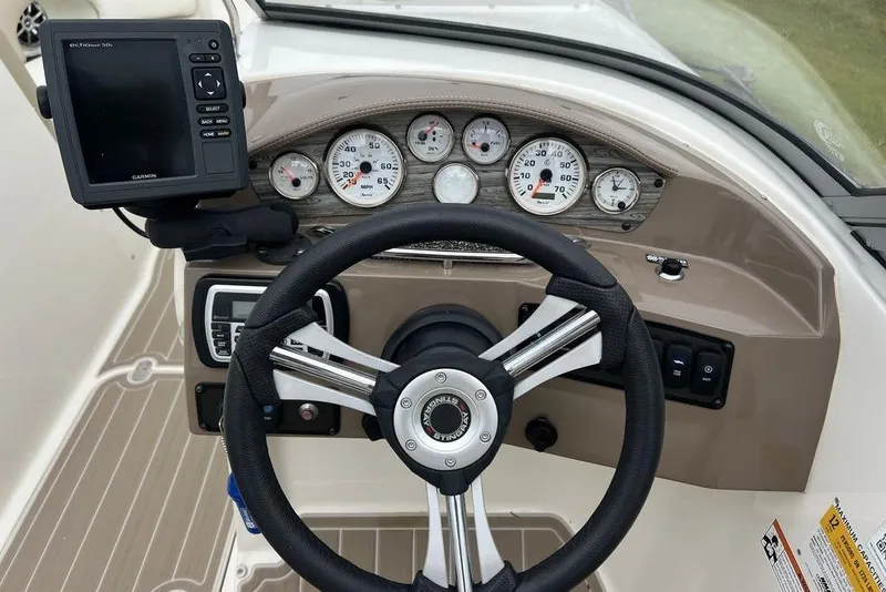 Slide: The Image of 2015 Stingray 234LR boat dashboard with steering wheel and Garmin navigation system. - 19