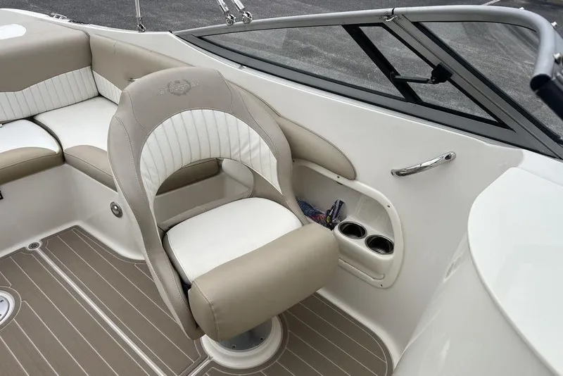 Slide: The Image of 2015 Stingray 234LR boat interior with beige and white seating, cup holders, and sleek design. - 23
