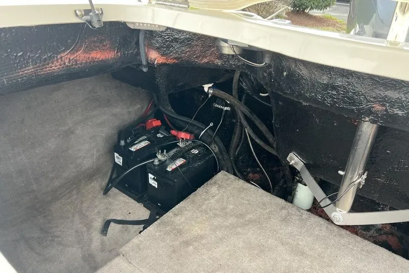 Slide: The Image of 2015 Stingray 234LR boat battery compartment with dual batteries and wiring. - 27