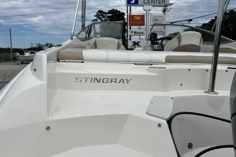 Slide: The Image of 2015 Stingray 234LR boat interior with logo, showcasing seating and dashboard. - 34