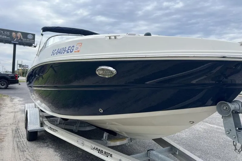 Slide: The Image of 2015 Stingray 234LR boat on trailer, parked outdoors under cloudy sky. - 5