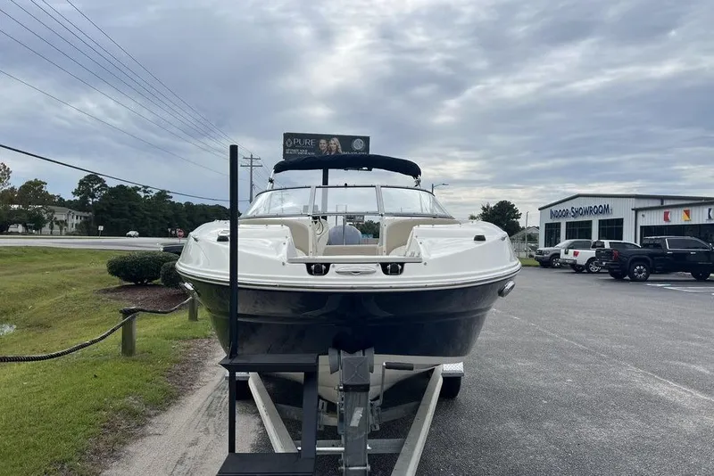 Slide: The Image of 2015 Stingray 234LR boat on trailer outside showroom under cloudy sky. - 7