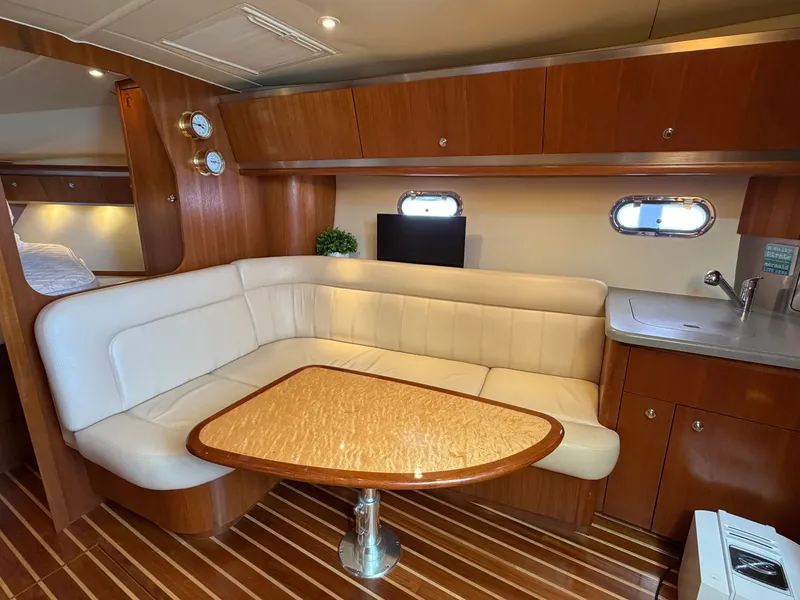 Slide: The Image of 2006 Tiara Yachts 3600 Sovran interior with white seating and nautical-themed cushions. - 21