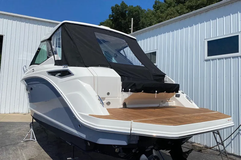 Slide: The Image of 2021 Sea Ray Sundancer 320 Coupe with black canopy, docked near a white building. - 5