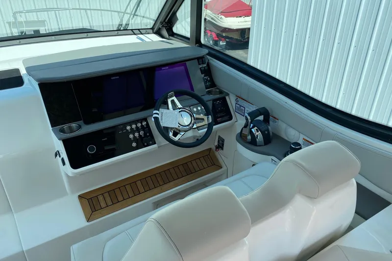 Slide: The Image of 2021 Sea Ray Sundancer 320 Coupe helm with modern controls and sleek design. - 6