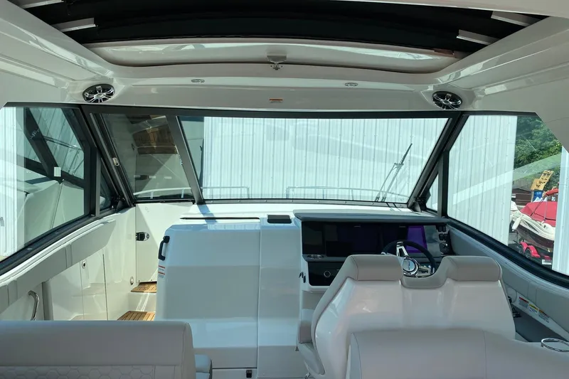 Slide: The Image of 2021 Sea Ray Sundancer 320 Coupe interior with modern helm and panoramic windows. - 7