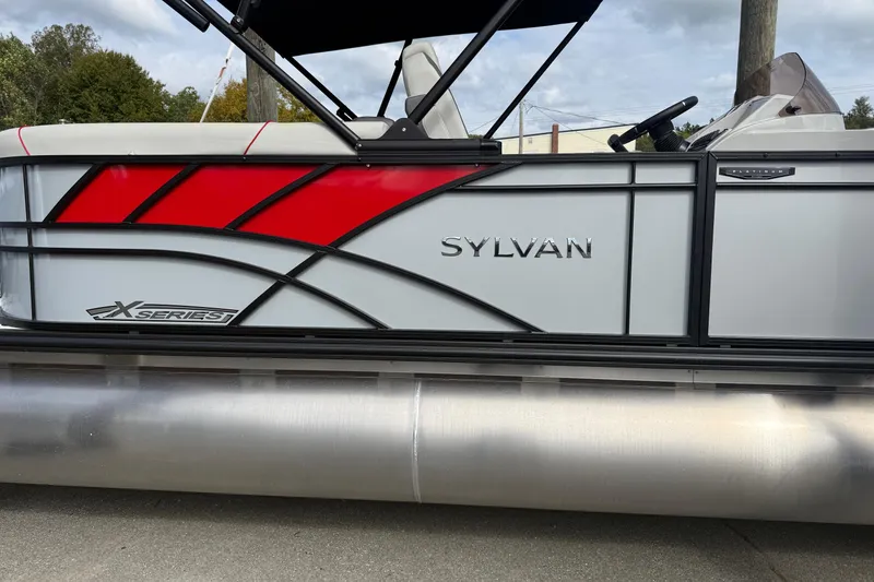 The Image of 2026 Sylvan X-3 LZ DH pontoon boat with red and gray design, side view. - 1