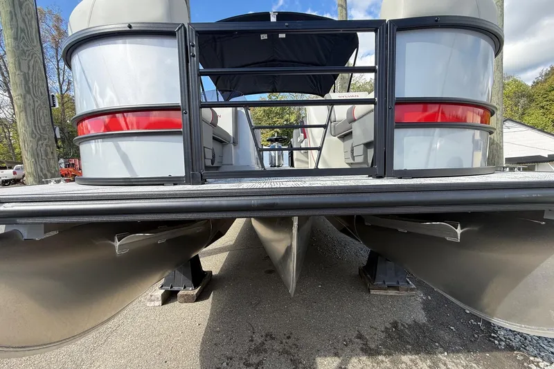 Slide: The Image of 2026 Sylvan X-3 LZ DH pontoon boat, docked, showcasing sleek design and sturdy pontoons. - 24