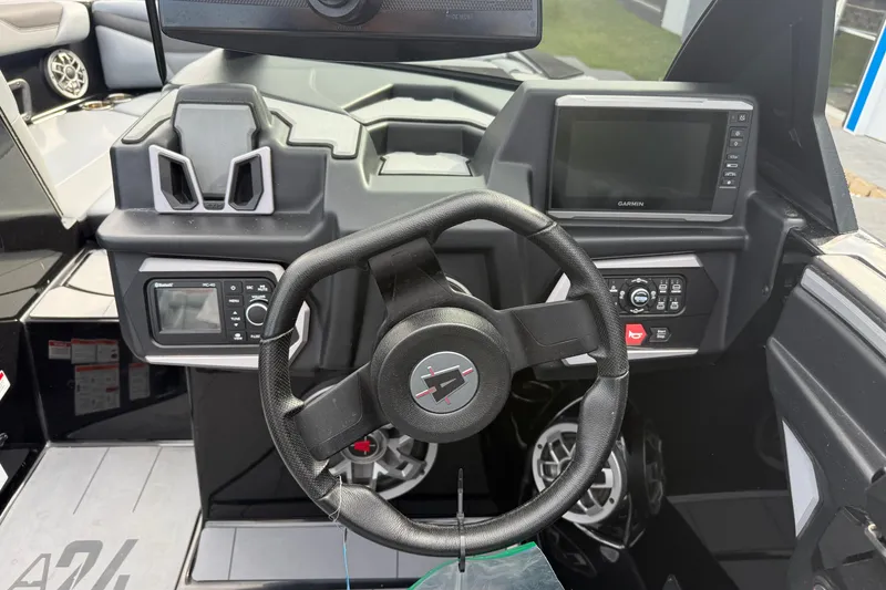 Slide: The Image of 2022 Axis A24 boat dashboard with steering wheel, Garmin display, and control panel. - 13