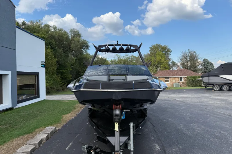 Slide: The Image of 2022 Axis A24 boat on trailer, parked outdoors under a clear blue sky. - 2