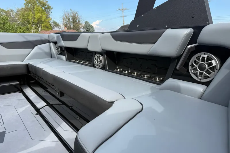 Slide: The Image of 2022 Axis A24 boat interior with gray seating, speakers, and cup holders. - 20