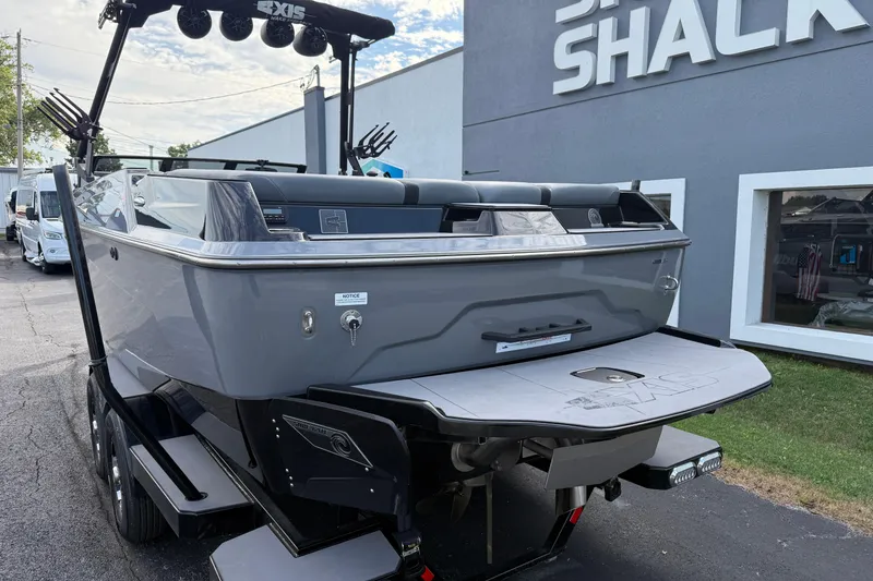 Slide: The Image of 2022 Axis A24 boat in gray, parked outside a dealership, showcasing rear design. - 6