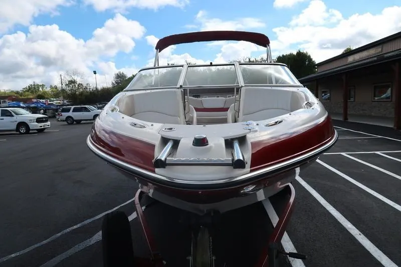 Slide: The Image of 2007 Glastron GLX 205 boat with red and white exterior, parked in a lot. - 7