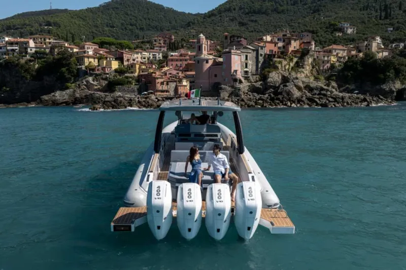 Slide: The Image of 2026 Ranieri CAYMAN 50 HARDTOP yacht cruising near scenic coastal village. - 37