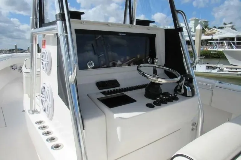 Slide: The Image of 2019 Contender 39 ST boat console with steering wheel and controls, docked at marina. - 14