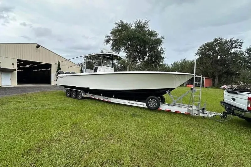 Slide: The Image of 2019 Contender 39 ST boat on trailer near a large warehouse. - 3