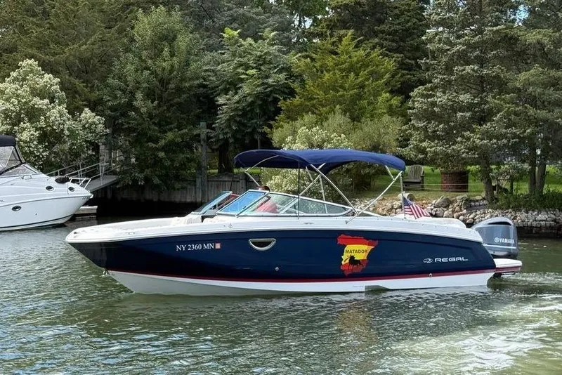 The Image of 2017 Regal 26 OBX boat on water, surrounded by lush greenery. - 0