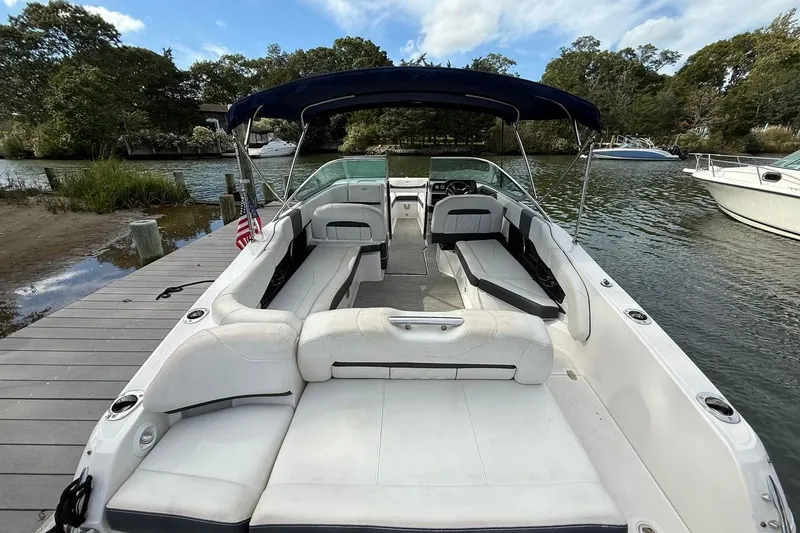 Slide: The Image of 2017 Regal 26 OBX boat with spacious seating, docked by a scenic river. - 11