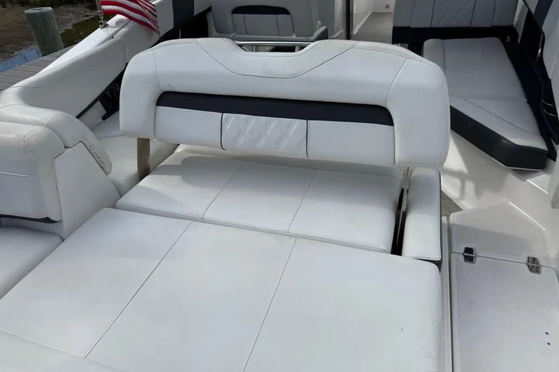 Slide: The Image of 2017 Regal 26 OBX boat interior with white cushioned seating and American flag. - 12