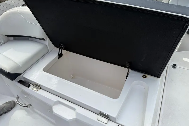 Slide: The Image of Open storage compartment on 2017 Regal 26 OBX boat, featuring white seating and sleek design. - 15
