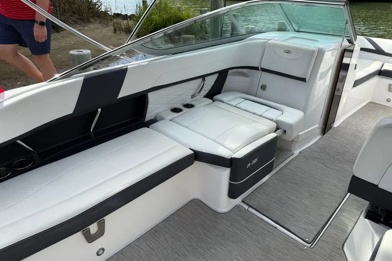 Slide: The Image of 2017 Regal 26 OBX boat interior with white seating and cup holders. - 17