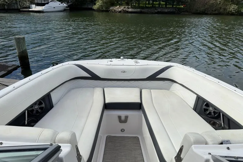 Slide: The Image of 2017 Regal 26 OBX boat with spacious white seating, docked by calm waters. - 24